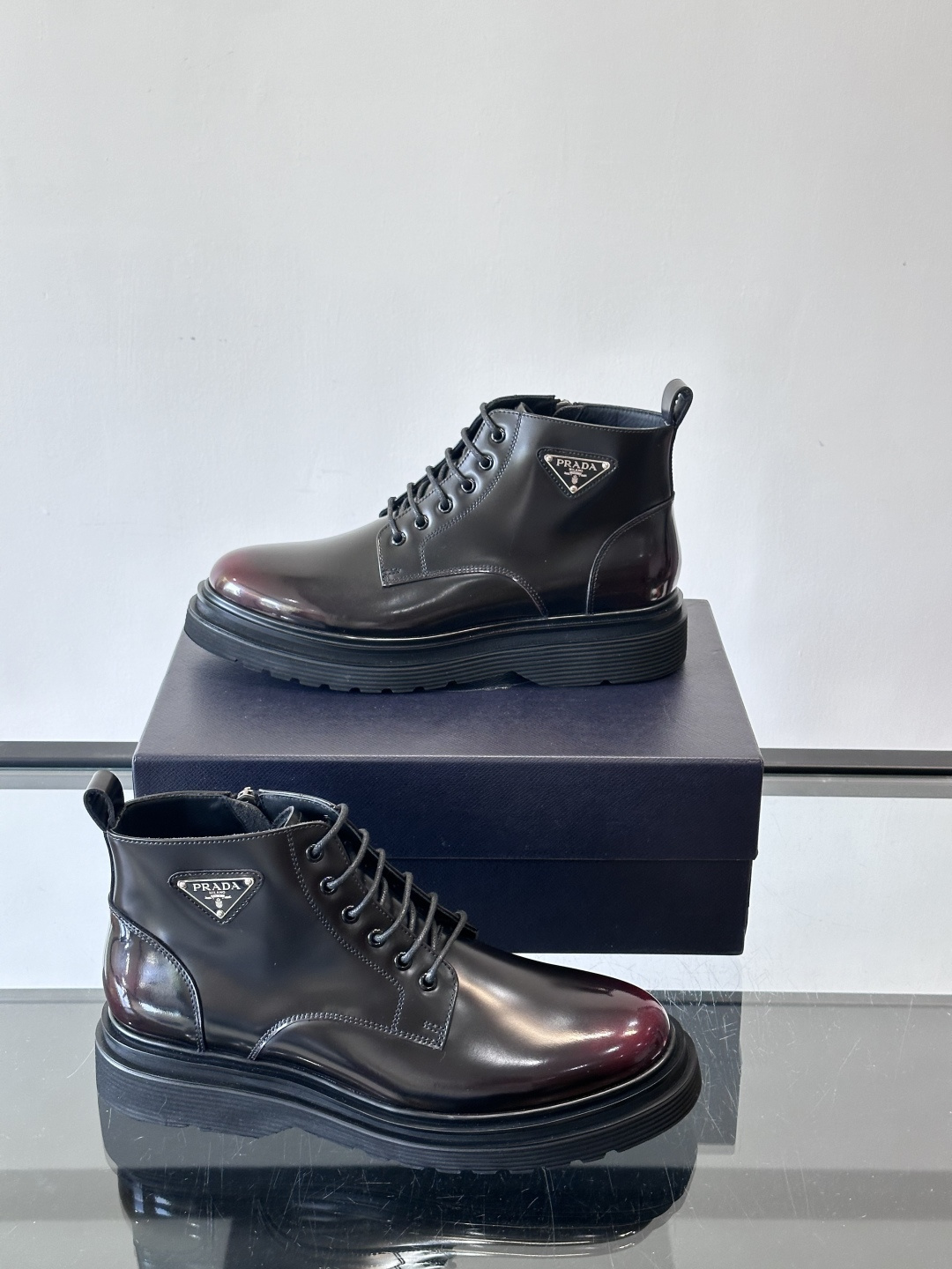 Prada这款男士商务马丁靴，选用优质牛皮，鞋面光滑有质感，搭配经典三角标，低调又有辦识度。厚底橡胶鞋底