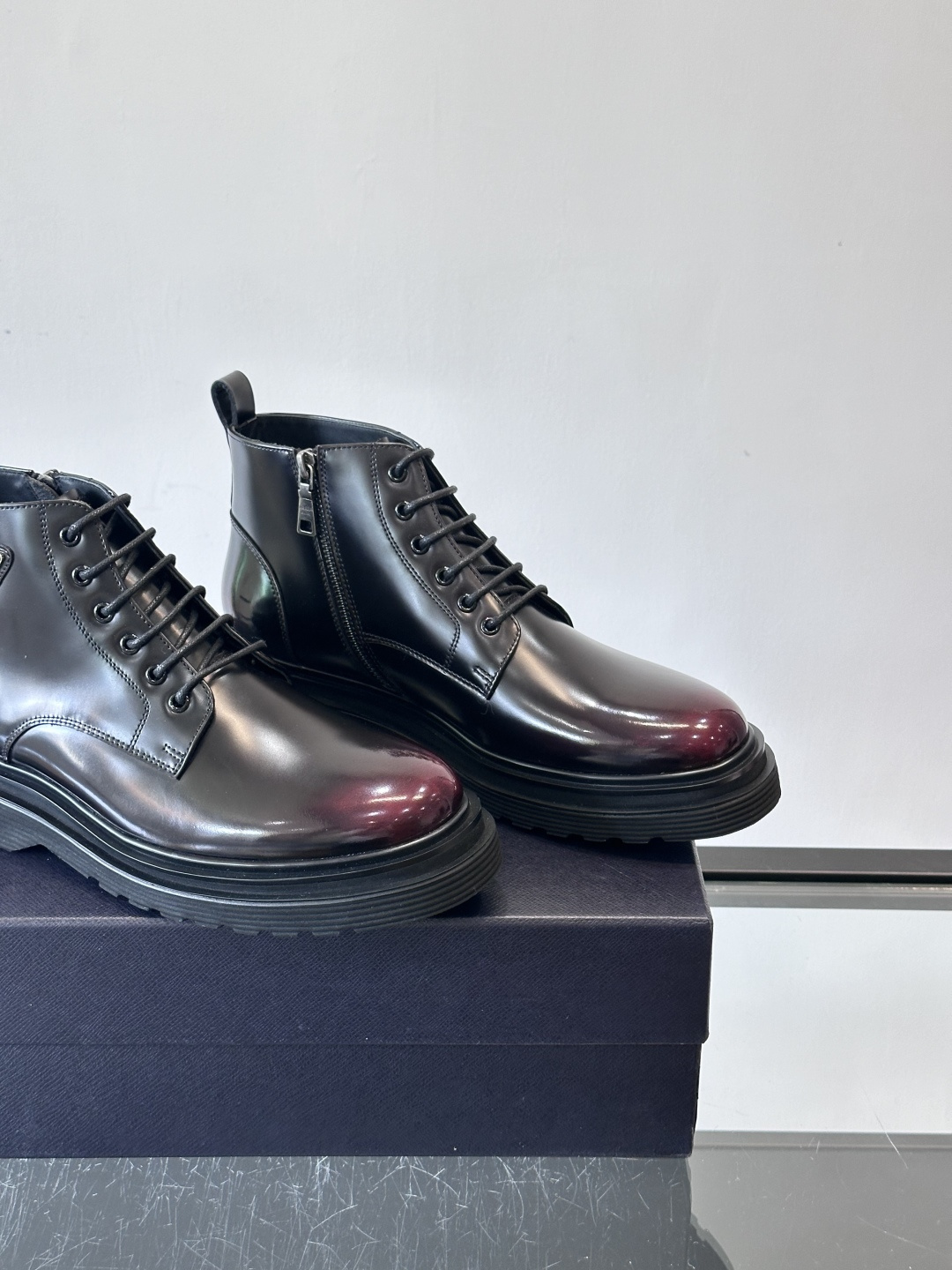 Prada这款男士商务马丁靴，选用优质牛皮，鞋面光滑有质感，搭配经典三角标，低调又有辦识度。厚底橡胶鞋底