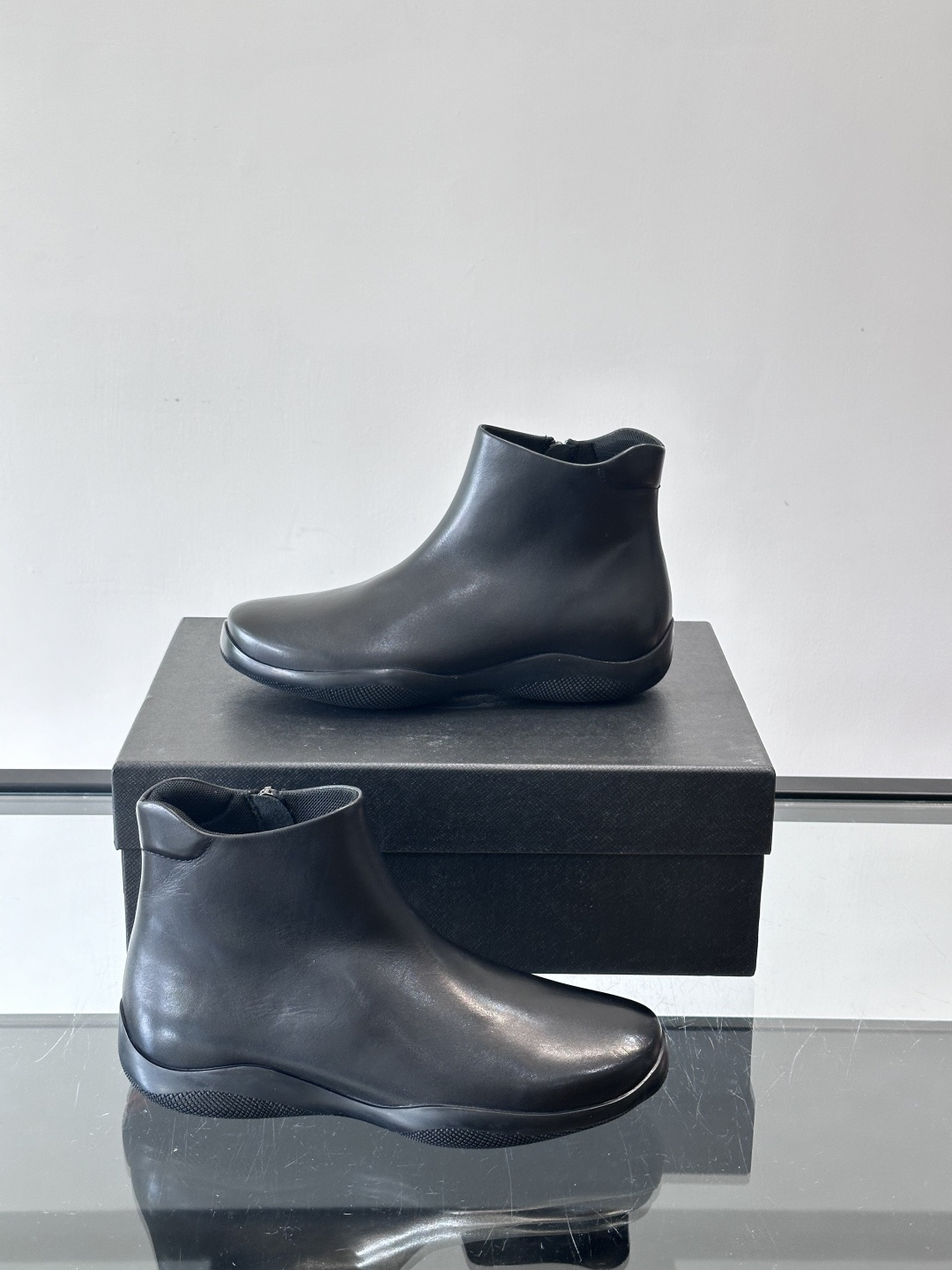 Prada黑色真皮切尔西靴这款黑色真皮切尔西靴选用优质牛皮，鞋面光滑细腻，质感满。经典套脚设计+侧边拉链