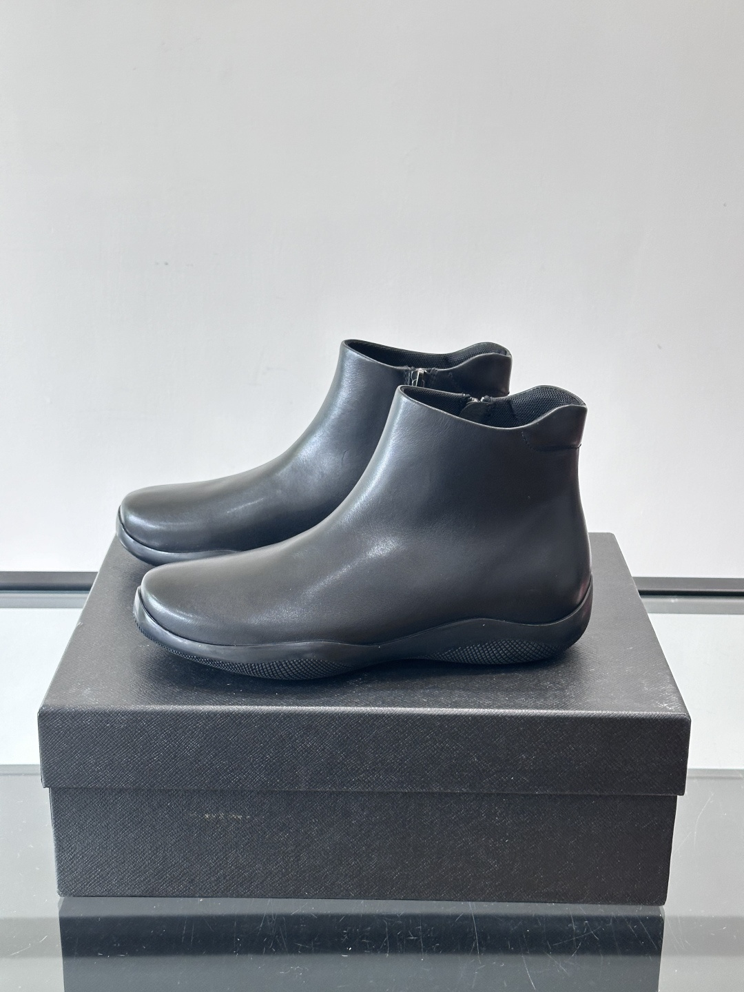 Prada黑色真皮切尔西靴这款黑色真皮切尔西靴选用优质牛皮，鞋面光滑细腻，质感满。经典套脚设计+侧边拉链