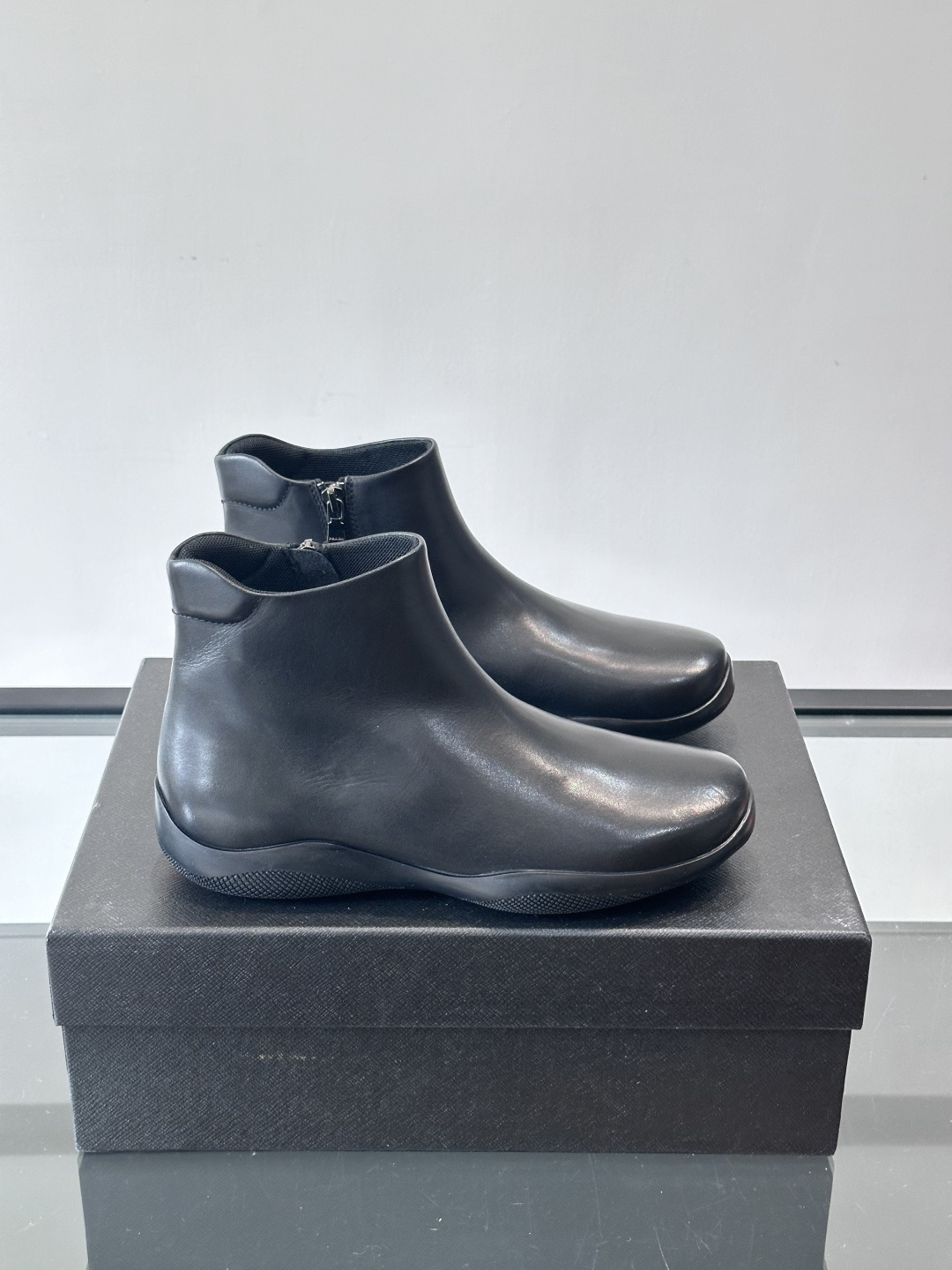 Prada黑色真皮切尔西靴这款黑色真皮切尔西靴选用优质牛皮，鞋面光滑细腻，质感满。经典套脚设计+侧边拉链
