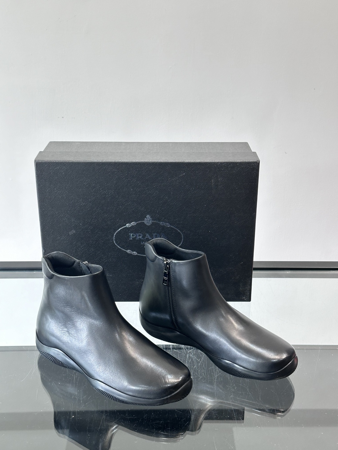 Prada黑色真皮切尔西靴这款黑色真皮切尔西靴选用优质牛皮，鞋面光滑细腻，质感满。经典套脚设计+侧边拉链