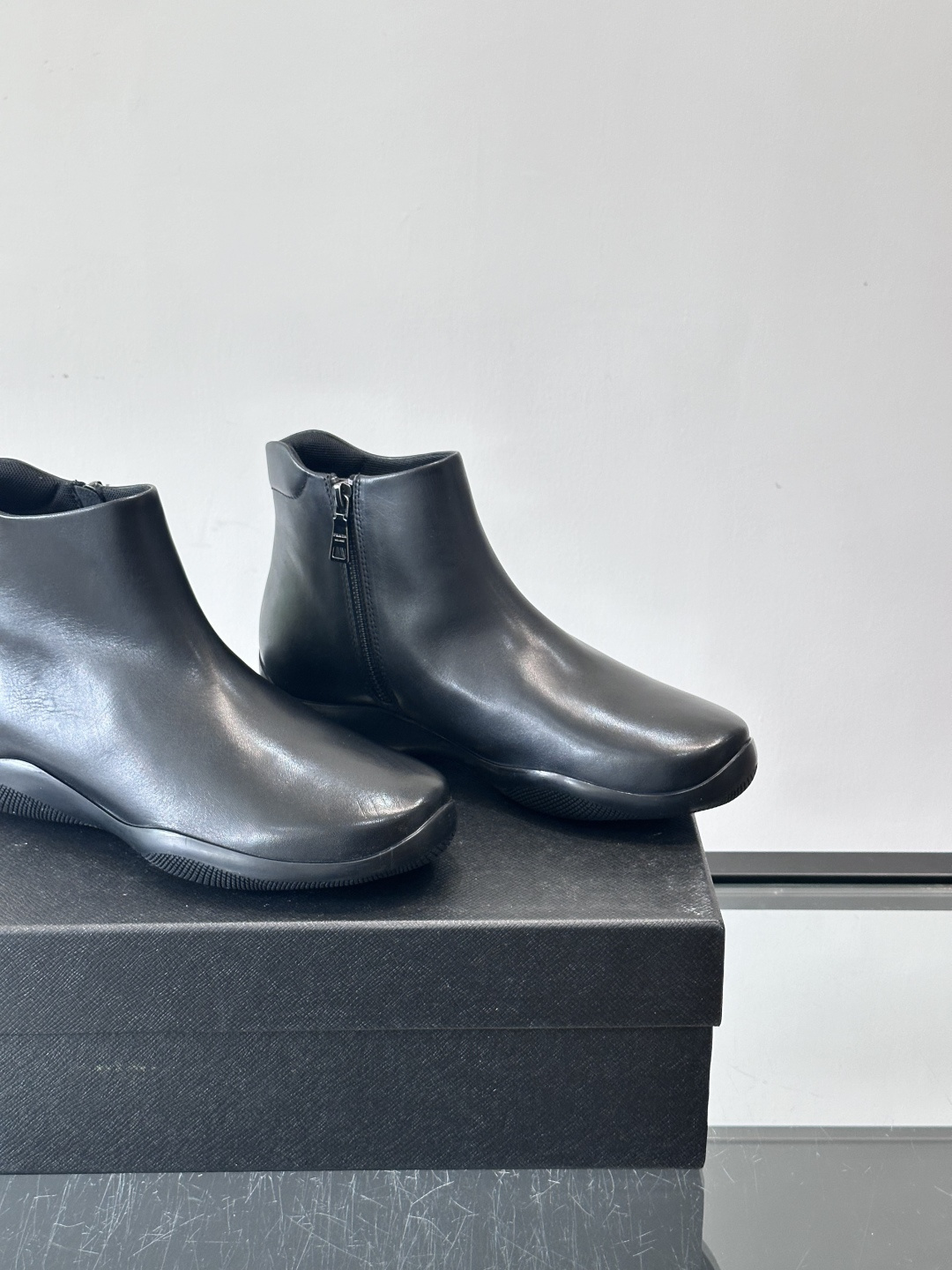 Prada黑色真皮切尔西靴这款黑色真皮切尔西靴选用优质牛皮，鞋面光滑细腻，质感满。经典套脚设计+侧边拉链