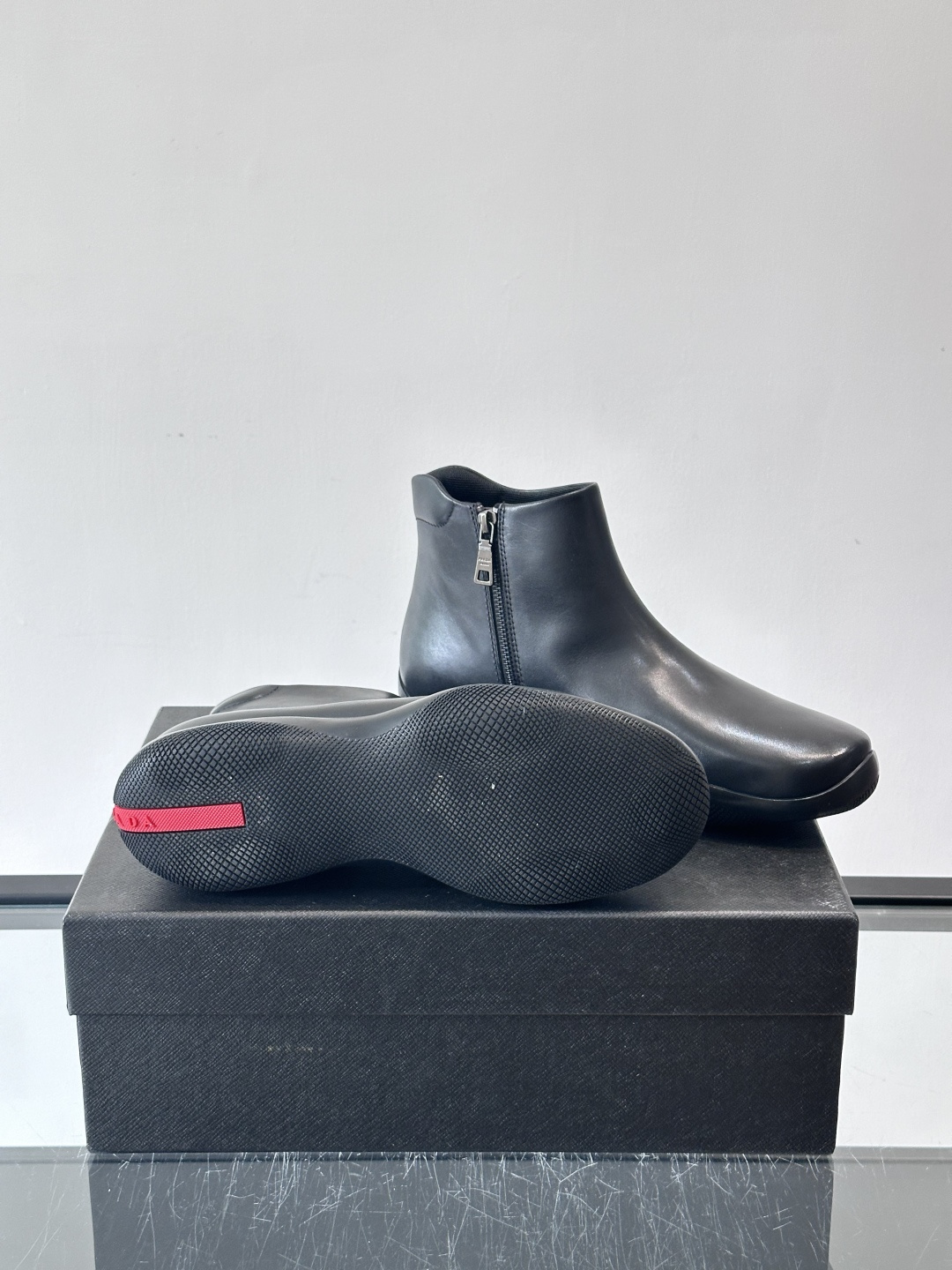 Prada黑色真皮切尔西靴这款黑色真皮切尔西靴选用优质牛皮，鞋面光滑细腻，质感满。经典套脚设计+侧边拉链