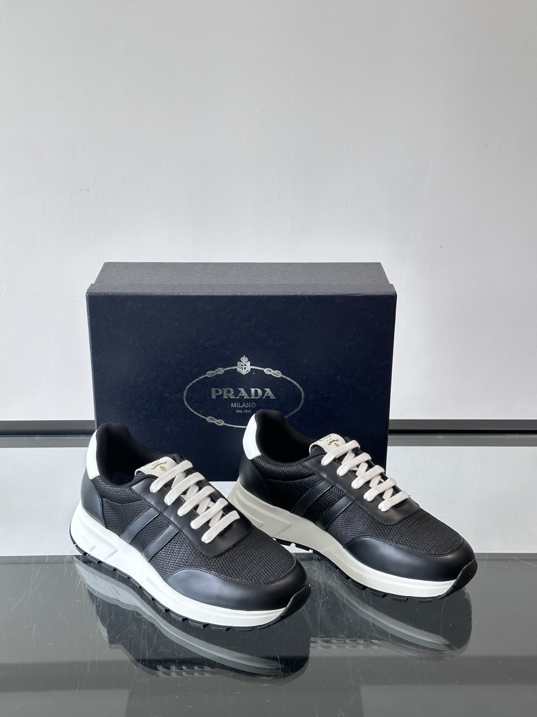 Prada复古运动鞋这款黑色复古运动鞋，网眼布+牛皮拼接，轻便透气，夏天穿超舒服！白色厚底设计，增高又缓