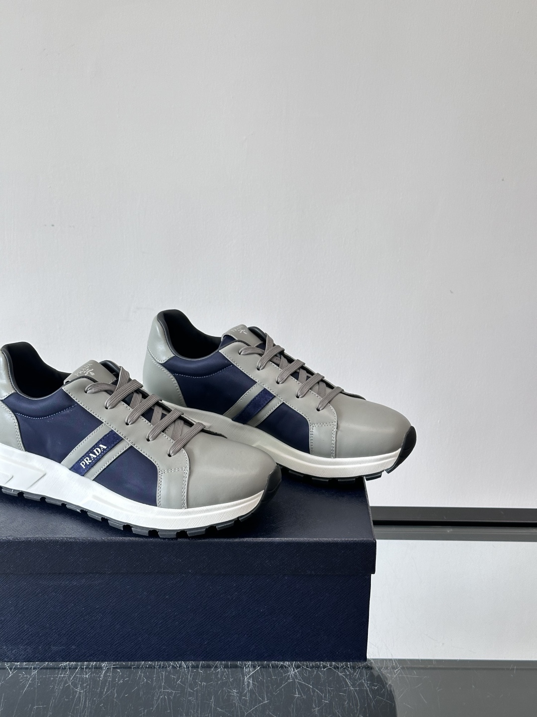 Prada 男士休闲运动鞋灵感来自经典赛车鞋，皮革+尼龙拼接，质感满分！侧面logo徽标超有辦识度，橡胶