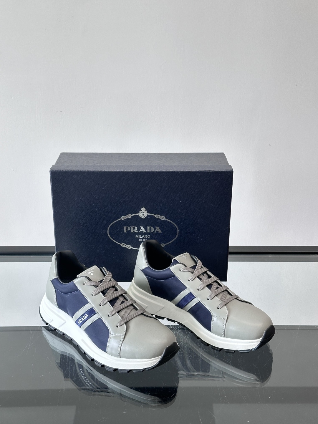 Prada 男士休闲运动鞋灵感来自经典赛车鞋，皮革+尼龙拼接，质感满分！侧面logo徽标超有辦识度，橡胶