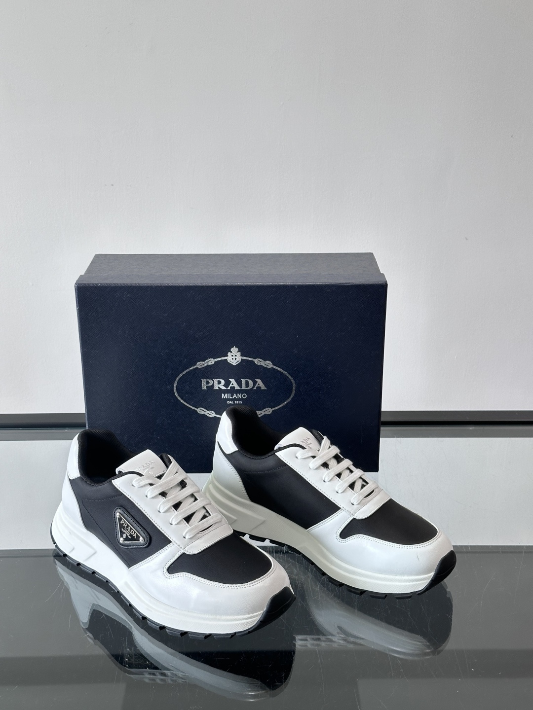 Prada 男士运动休闲鞋这款Prada男士运动休闲鞋👟配色超经典，简约又时髦！鞋面用牛皮革+织物，穿着