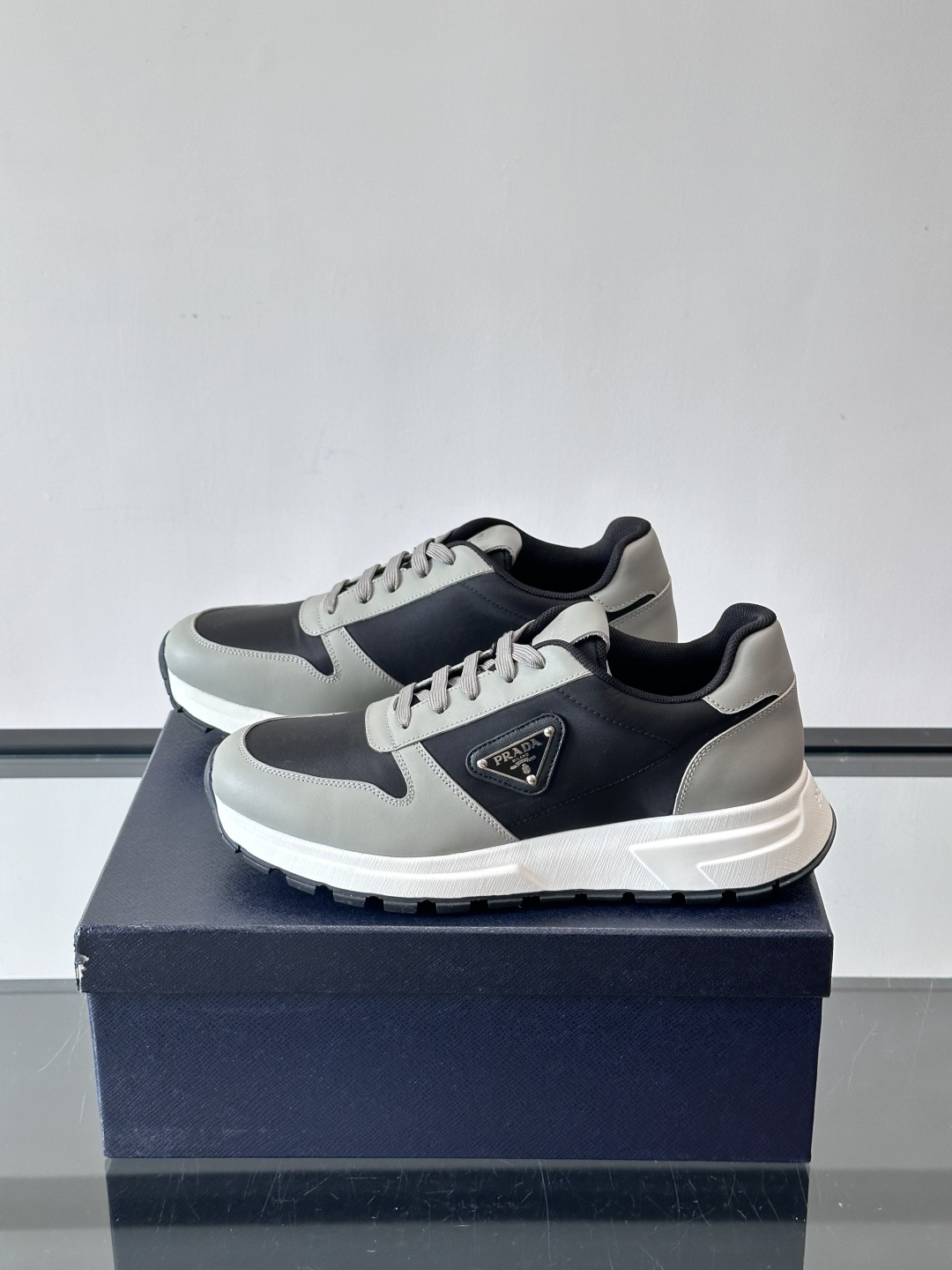 Prada 男士运动休闲鞋这款Prada男士运动休闲鞋👟配色超经典，简约又时髦！鞋面用牛皮革+织物，穿着