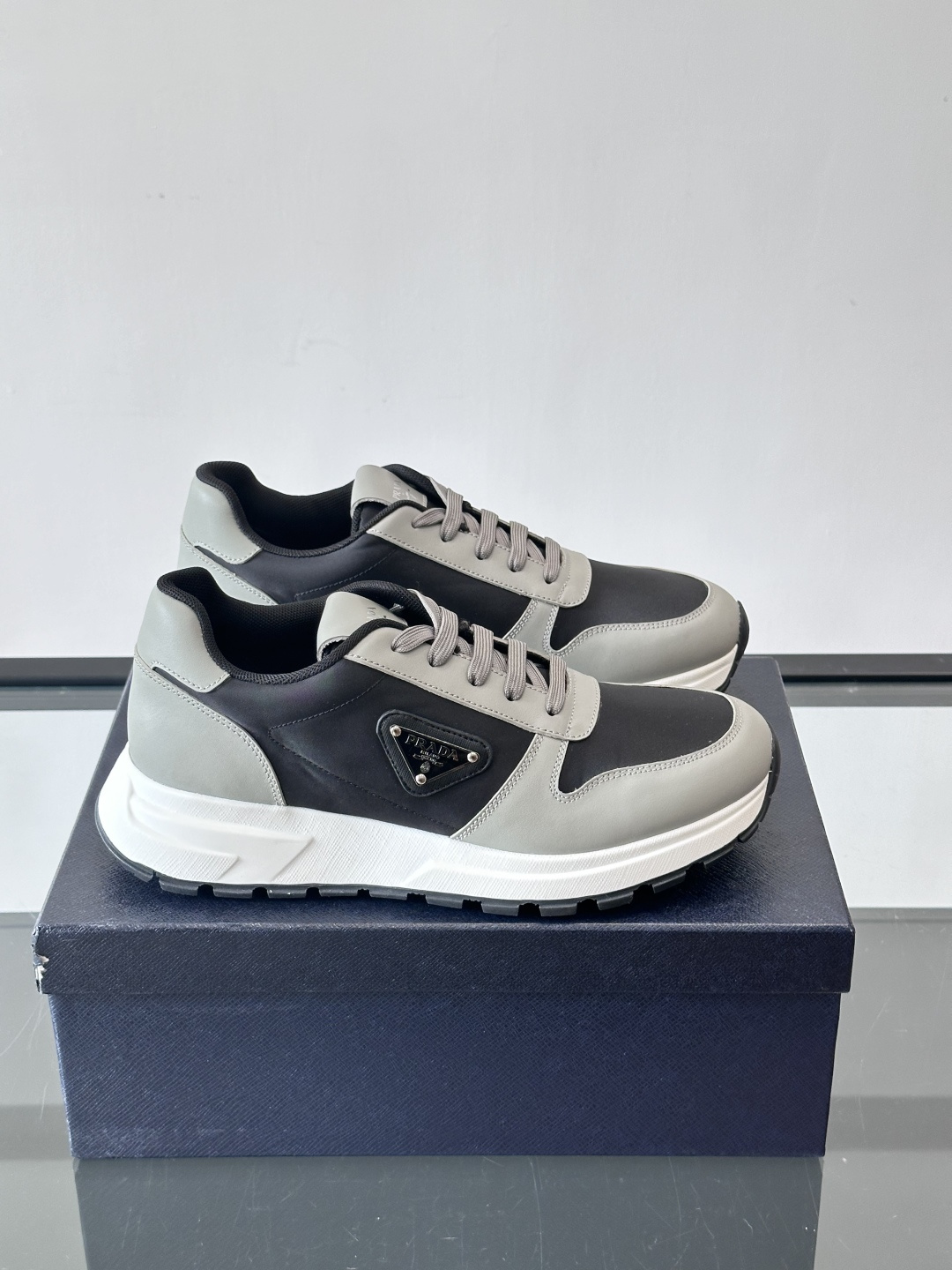 Prada 男士运动休闲鞋这款Prada男士运动休闲鞋👟配色超经典，简约又时髦！鞋面用牛皮革+织物，穿着