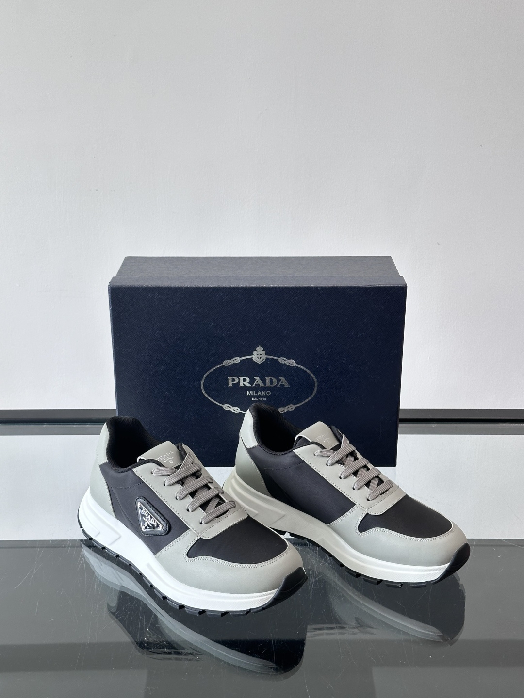 Prada 男士运动休闲鞋这款Prada男士运动休闲鞋👟配色超经典，简约又时髦！鞋面用牛皮革+织物，穿着