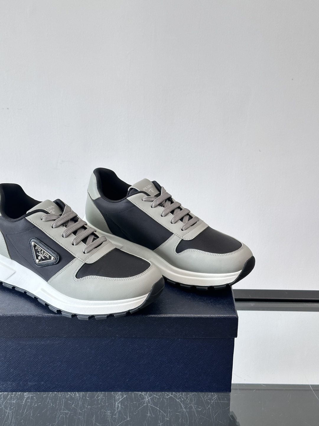 Prada 男士运动休闲鞋这款Prada男士运动休闲鞋👟配色超经典，简约又时髦！鞋面用牛皮革+织物，穿着