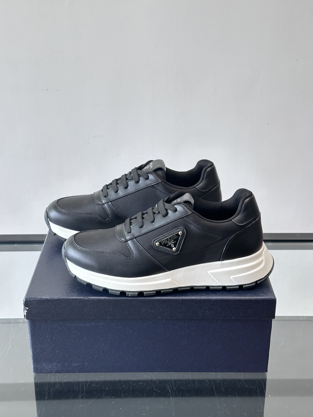 Prada 男士运动休闲鞋这款Prada男士运动休闲鞋👟配色超经典，简约又时髦！鞋面用牛皮革+织物，穿着