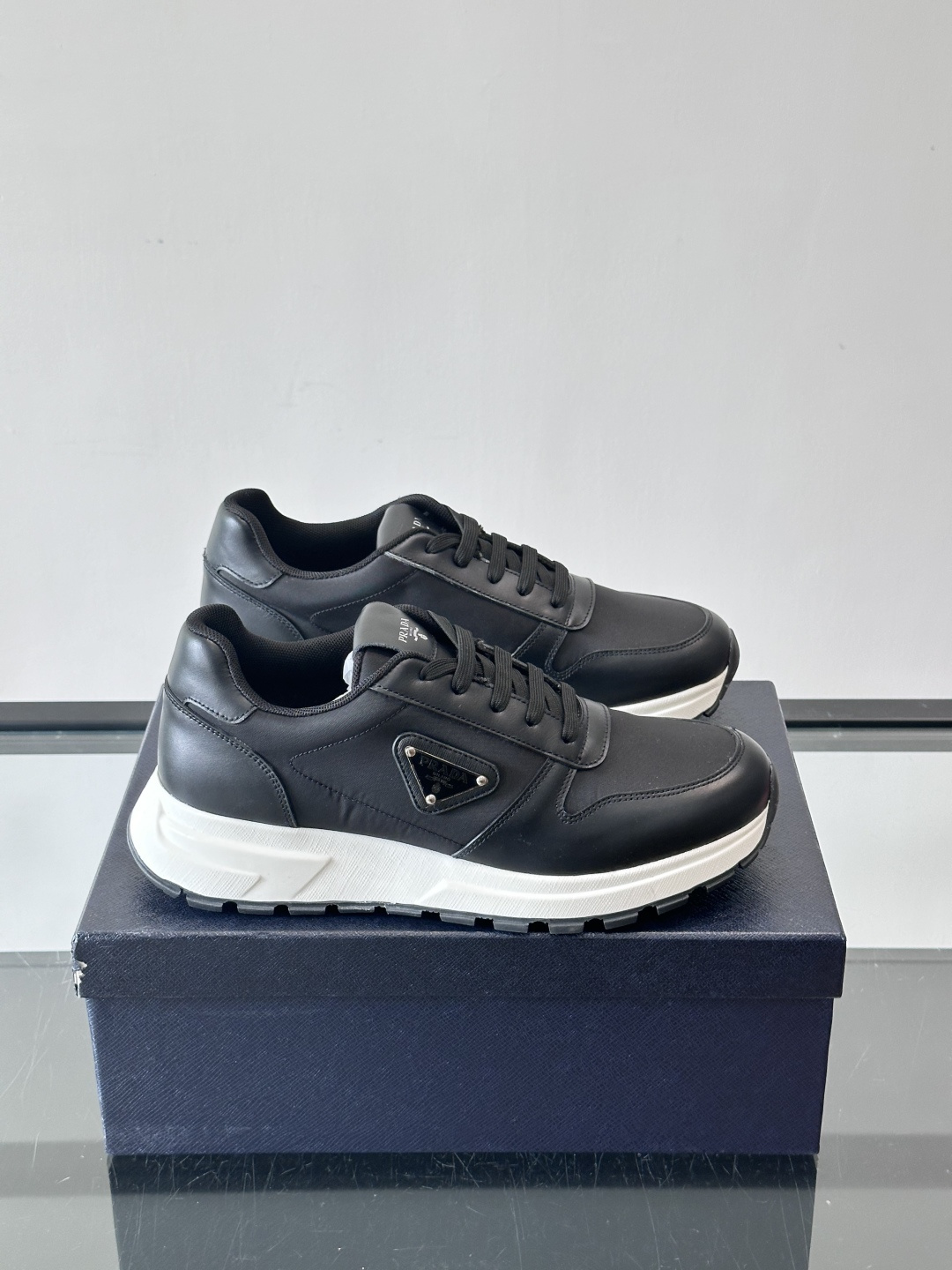 Prada 男士运动休闲鞋这款Prada男士运动休闲鞋👟配色超经典，简约又时髦！鞋面用牛皮革+织物，穿着