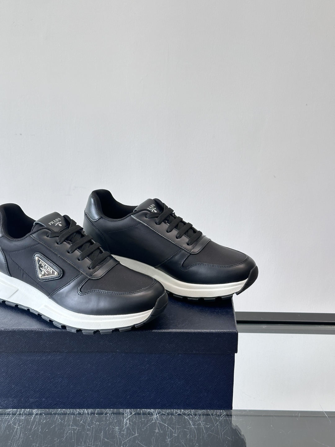 Prada 男士运动休闲鞋这款Prada男士运动休闲鞋👟配色超经典，简约又时髦！鞋面用牛皮革+织物，穿着
