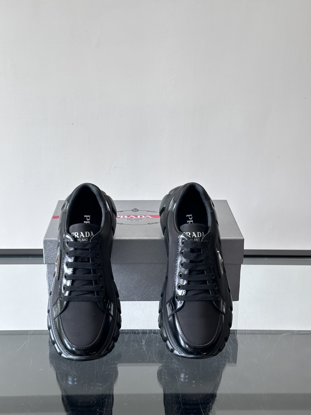 Prada三角标厚底运动鞋，选用纳帕小牛皮，鞋面柔软细腻，质感满分。侧面经典三角金属珐琅徽章+Logo鞋