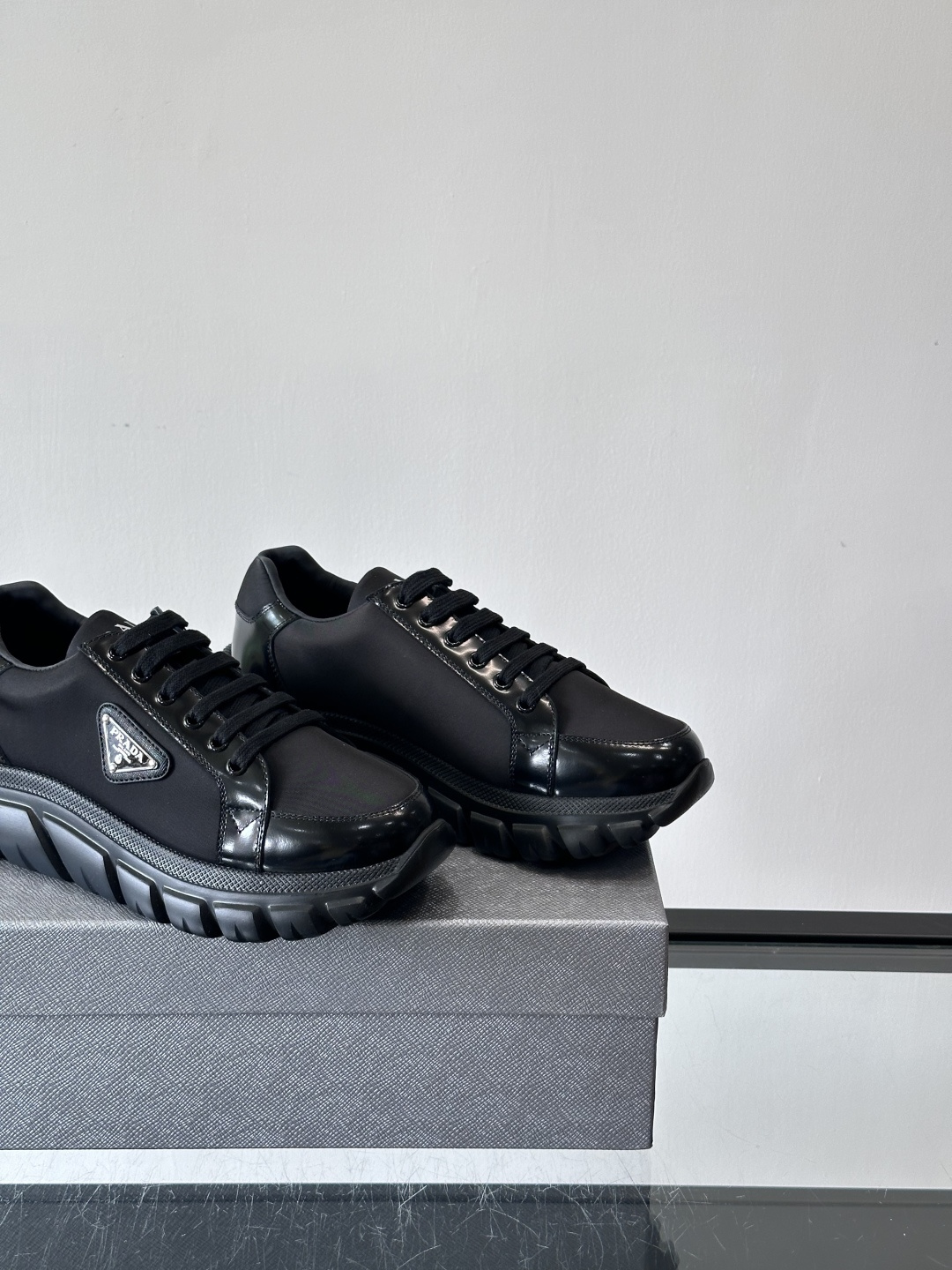 Prada三角标厚底运动鞋，选用纳帕小牛皮，鞋面柔软细腻，质感满分。侧面经典三角金属珐琅徽章+Logo鞋