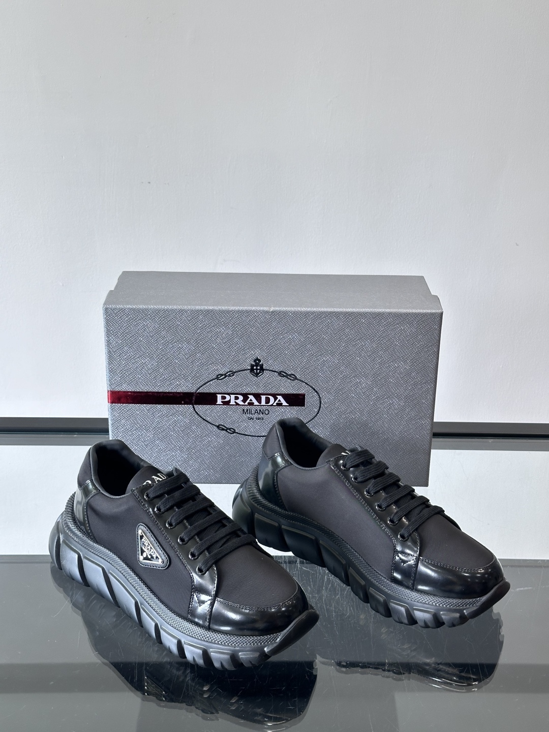 Prada三角标厚底运动鞋，选用纳帕小牛皮，鞋面柔软细腻，质感满分。侧面经典三角金属珐琅徽章+Logo鞋