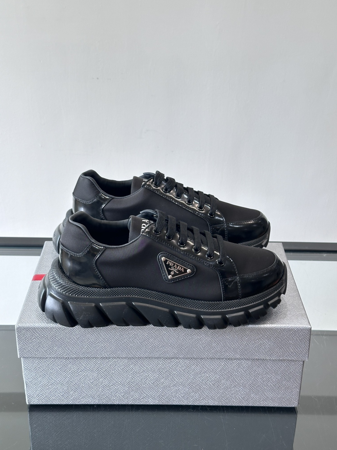 Prada三角标厚底运动鞋，选用纳帕小牛皮，鞋面柔软细腻，质感满分。侧面经典三角金属珐琅徽章+Logo鞋
