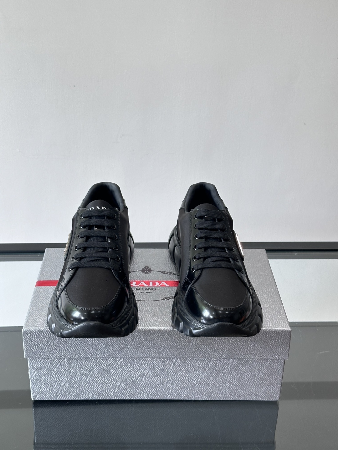 Prada三角标厚底运动鞋，选用纳帕小牛皮，鞋面柔软细腻，质感满分。侧面经典三角金属珐琅徽章+Logo鞋