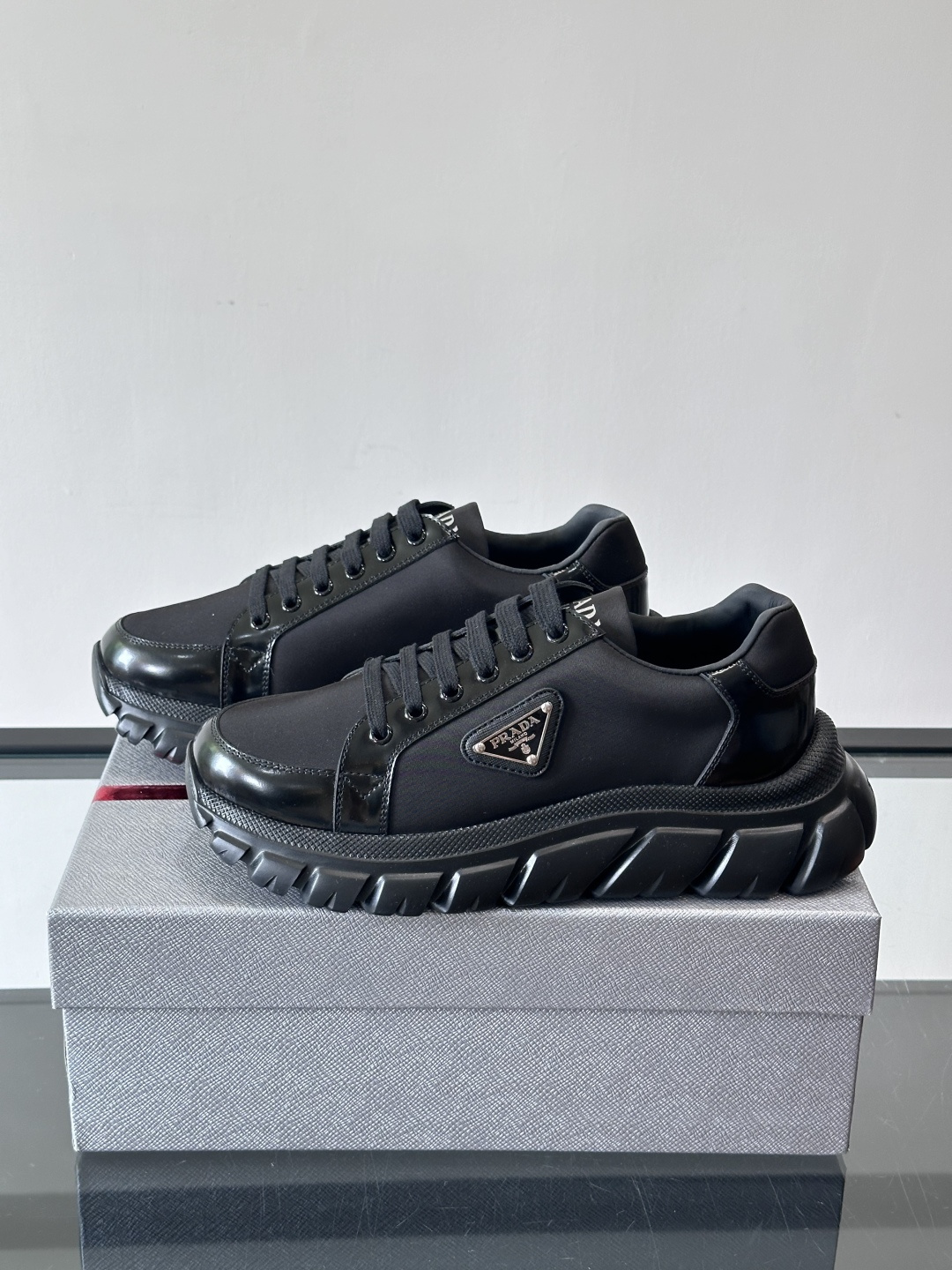 Prada三角标厚底运动鞋，选用纳帕小牛皮，鞋面柔软细腻，质感满分。侧面经典三角金属珐琅徽章+Logo鞋