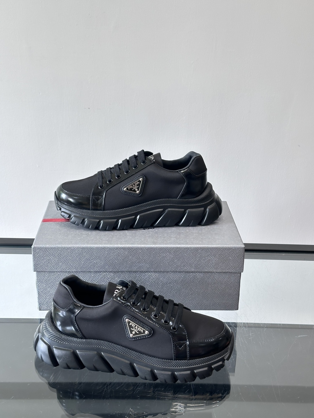 Prada三角标厚底运动鞋，选用纳帕小牛皮，鞋面柔软细腻，质感满分。侧面经典三角金属珐琅徽章+Logo鞋
