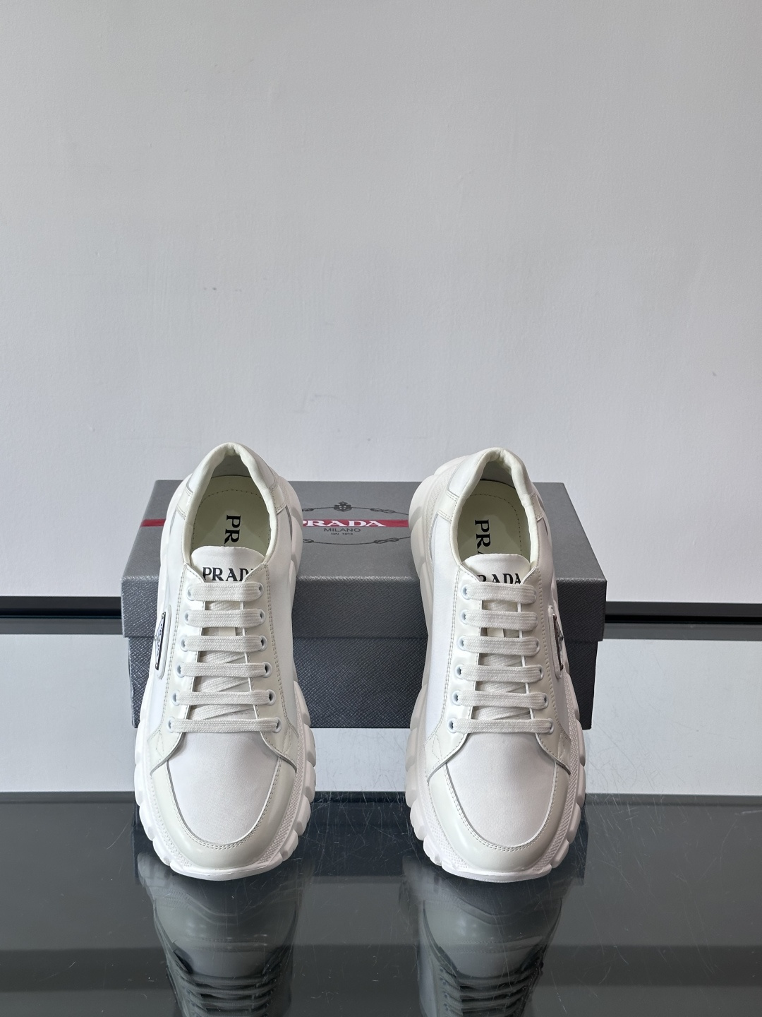 Prada三角标厚底运动鞋，选用纳帕小牛皮，鞋面柔软细腻，质感满分。侧面经典三角金属珐琅徽章+Logo鞋