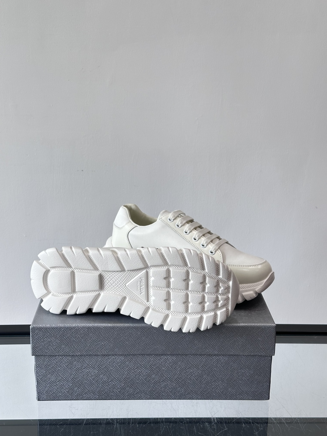 Prada三角标厚底运动鞋，选用纳帕小牛皮，鞋面柔软细腻，质感满分。侧面经典三角金属珐琅徽章+Logo鞋