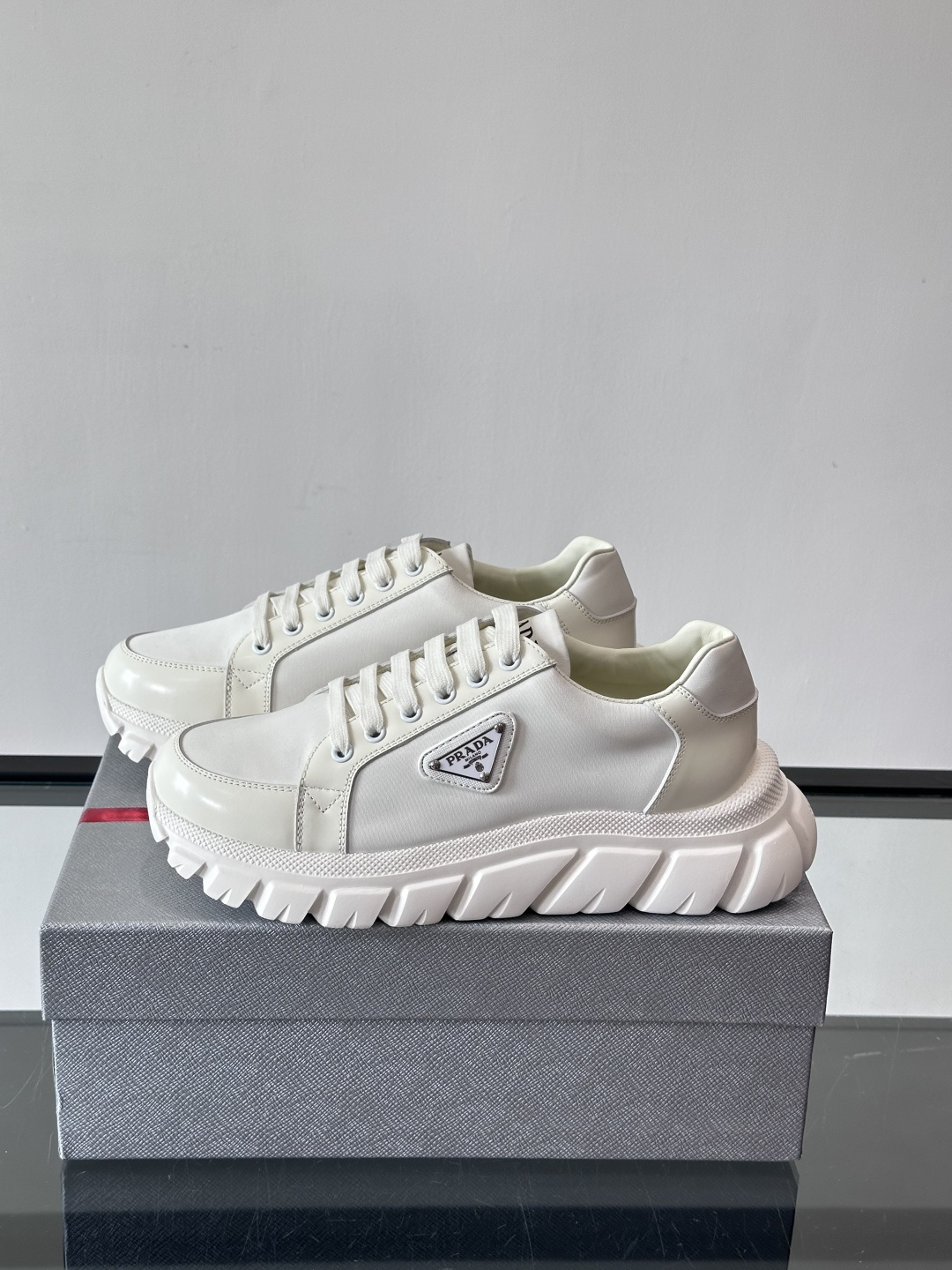 Prada三角标厚底运动鞋，选用纳帕小牛皮，鞋面柔软细腻，质感满分。侧面经典三角金属珐琅徽章+Logo鞋