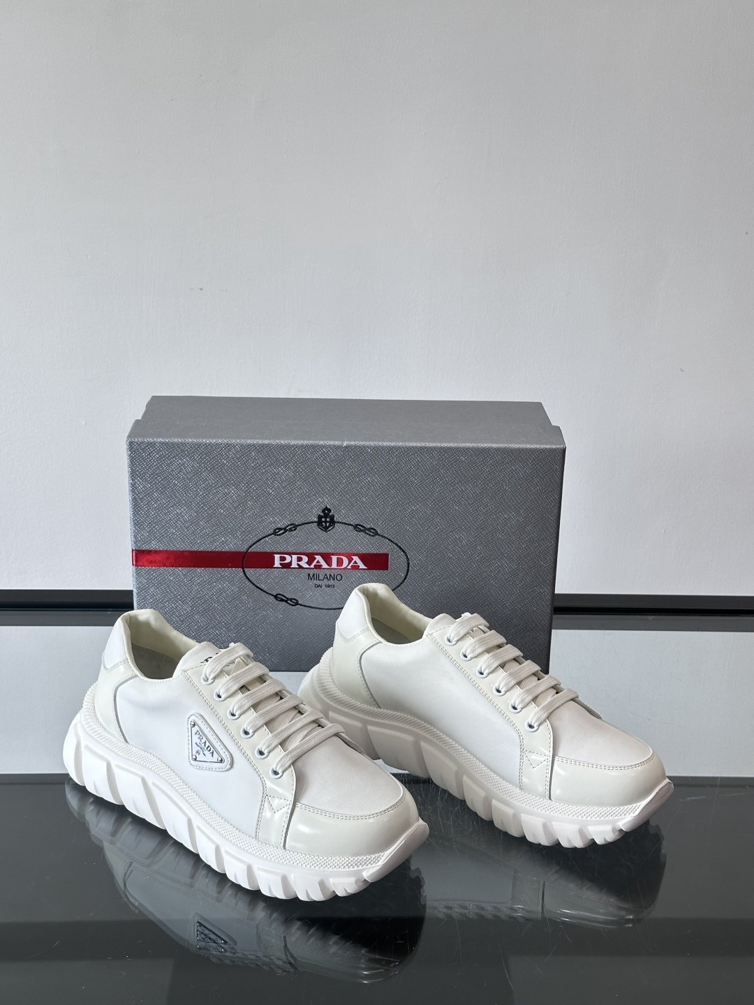 Prada三角标厚底运动鞋，选用纳帕小牛皮，鞋面柔软细腻，质感满分。侧面经典三角金属珐琅徽章+Logo鞋