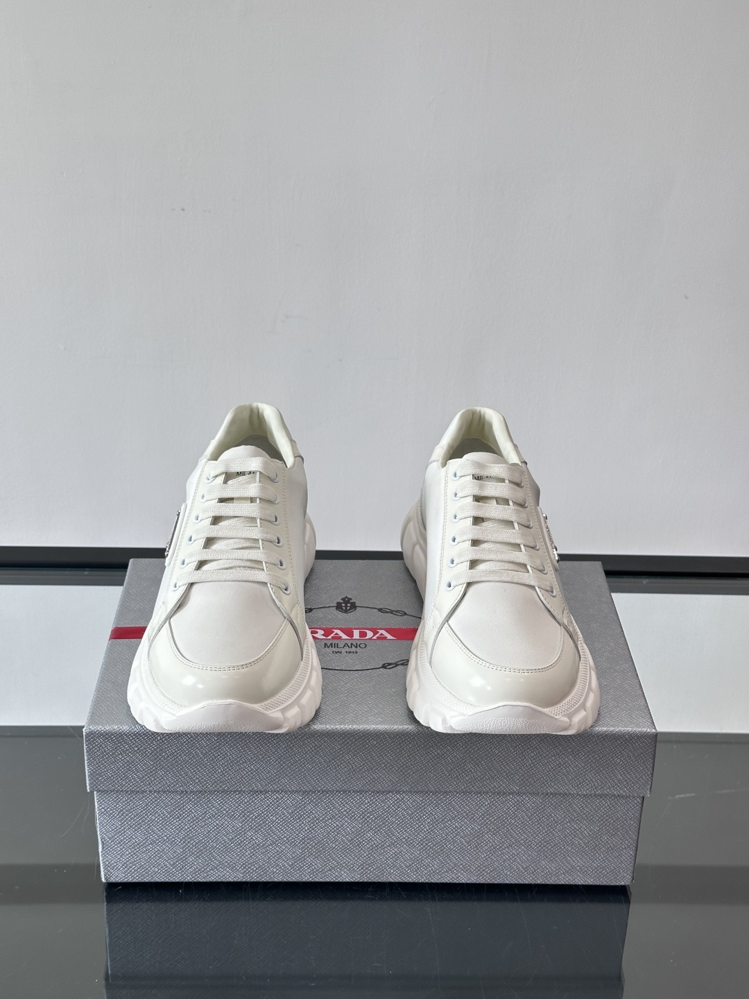 Prada三角标厚底运动鞋，选用纳帕小牛皮，鞋面柔软细腻，质感满分。侧面经典三角金属珐琅徽章+Logo鞋