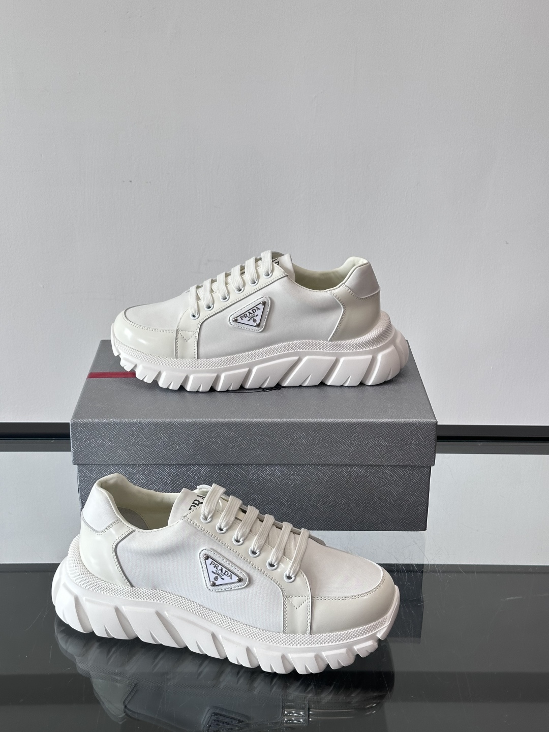 Prada三角标厚底运动鞋，选用纳帕小牛皮，鞋面柔软细腻，质感满分。侧面经典三角金属珐琅徽章+Logo鞋