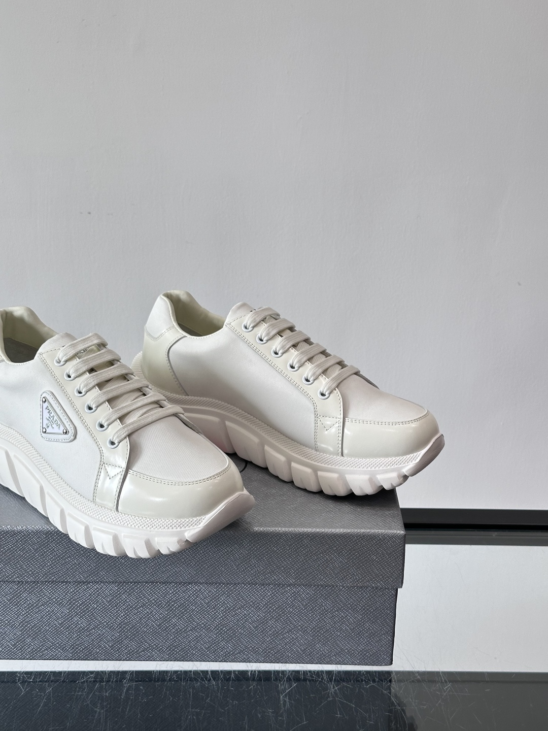 Prada三角标厚底运动鞋，选用纳帕小牛皮，鞋面柔软细腻，质感满分。侧面经典三角金属珐琅徽章+Logo鞋