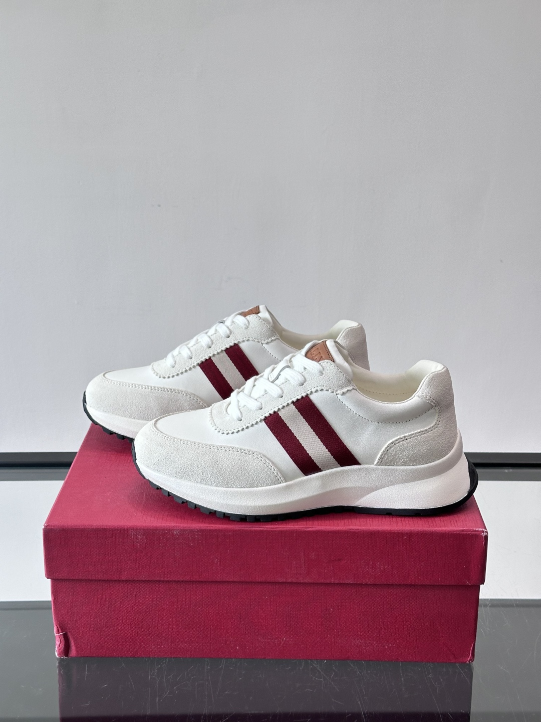 Bally男士休闲运动鞋，点缀酒红色条纹，复古感满满！鞋面采用牛皮革+织物拼接，透气又耐穿。厚底设计不仅