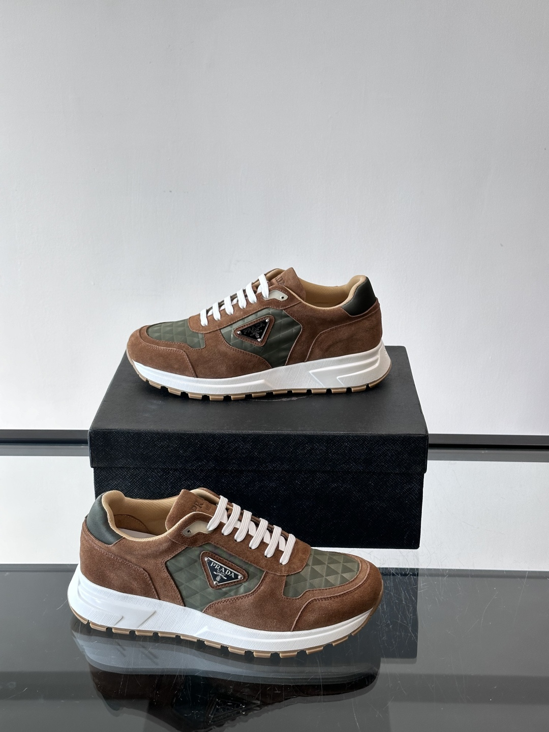 Prada 男士休闲运动鞋。采用麂皮与尼龙面料拼接，质感柔软又耐用，低调奢华。鞋侧三角徽标超有辨识度，橡