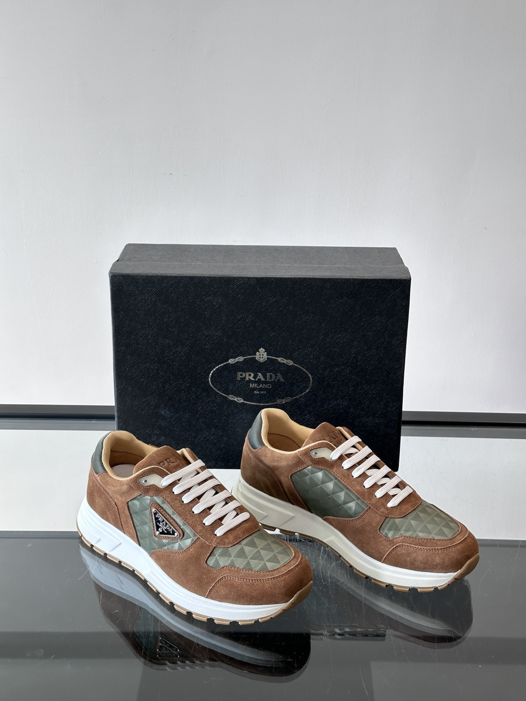 Prada 男士休闲运动鞋。采用麂皮与尼龙面料拼接，质感柔软又耐用，低调奢华。鞋侧三角徽标超有辨识度，橡