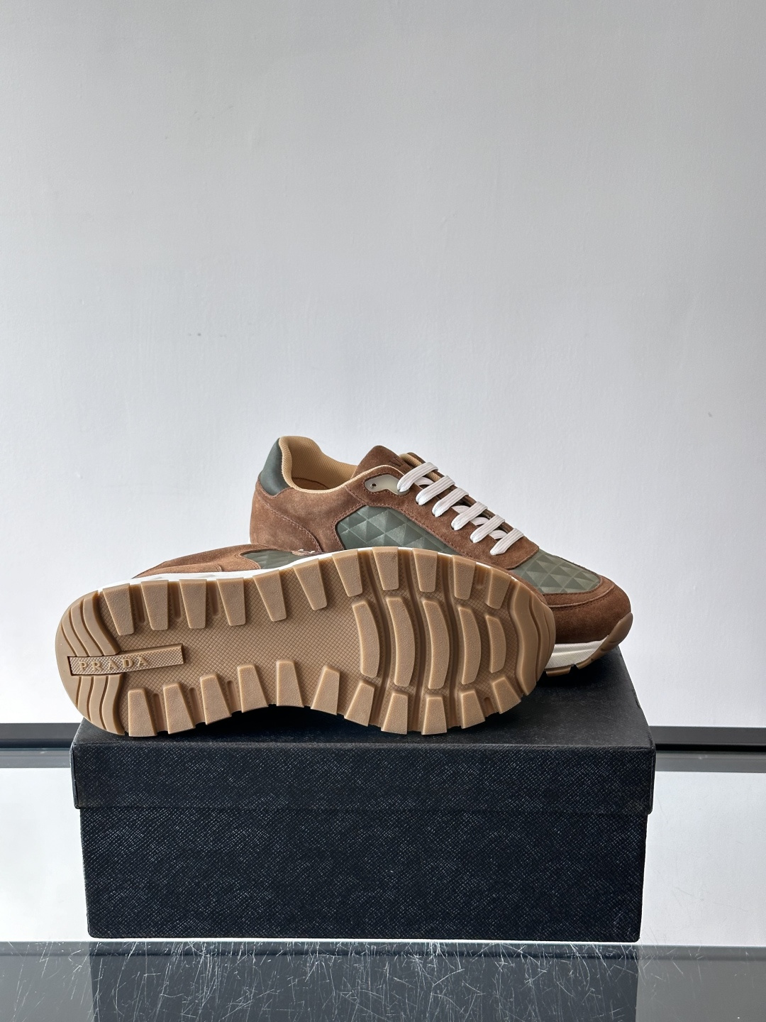 Prada 男士休闲运动鞋。采用麂皮与尼龙面料拼接，质感柔软又耐用，低调奢华。鞋侧三角徽标超有辨识度，橡