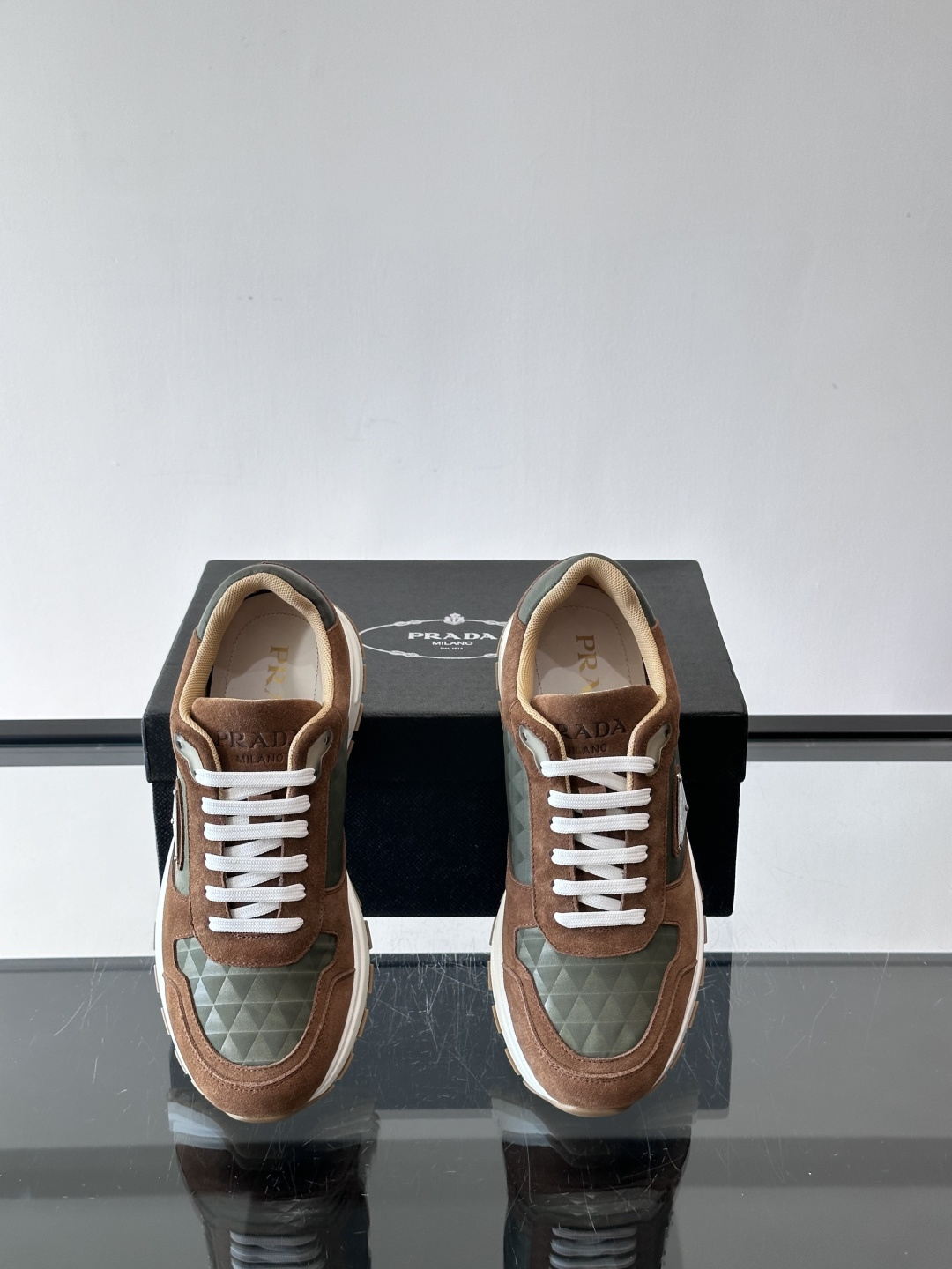 Prada 男士休闲运动鞋。采用麂皮与尼龙面料拼接，质感柔软又耐用，低调奢华。鞋侧三角徽标超有辨识度，橡