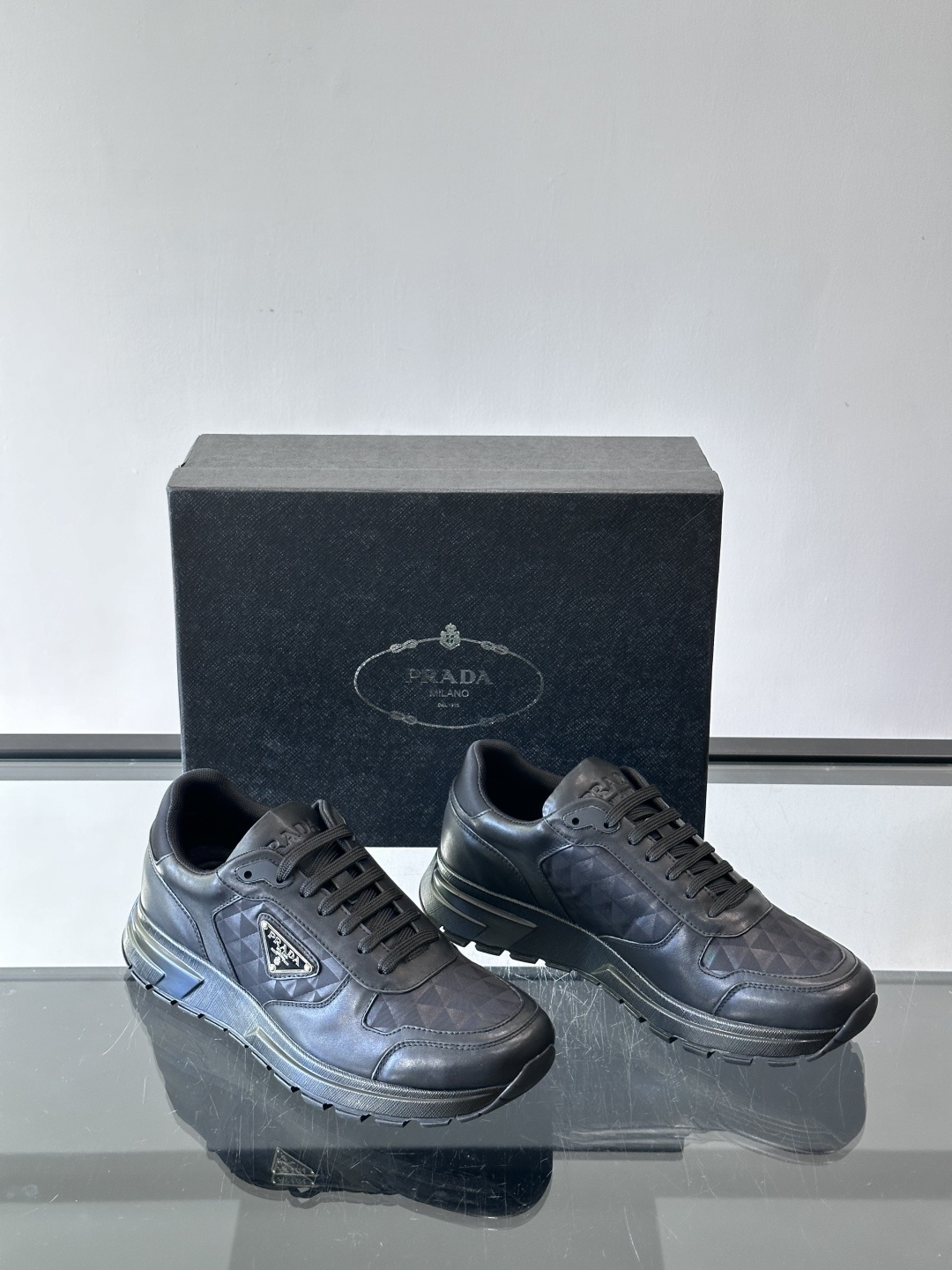 Prada 男士休闲运动鞋。采用麂皮与尼龙面料拼接，质感柔软又耐用，低调奢华。鞋侧三角徽标超有辨识度，橡