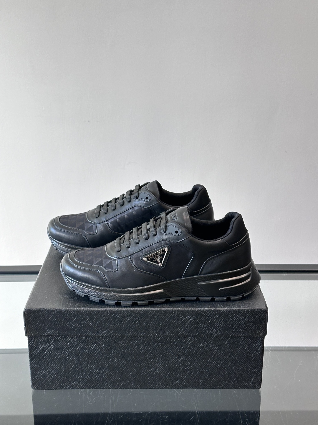 Prada 男士休闲运动鞋。采用麂皮与尼龙面料拼接，质感柔软又耐用，低调奢华。鞋侧三角徽标超有辨识度，橡