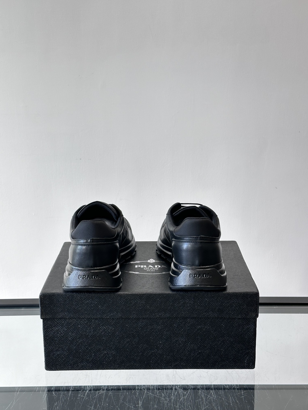 Prada 男士休闲运动鞋。采用麂皮与尼龙面料拼接，质感柔软又耐用，低调奢华。鞋侧三角徽标超有辨识度，橡