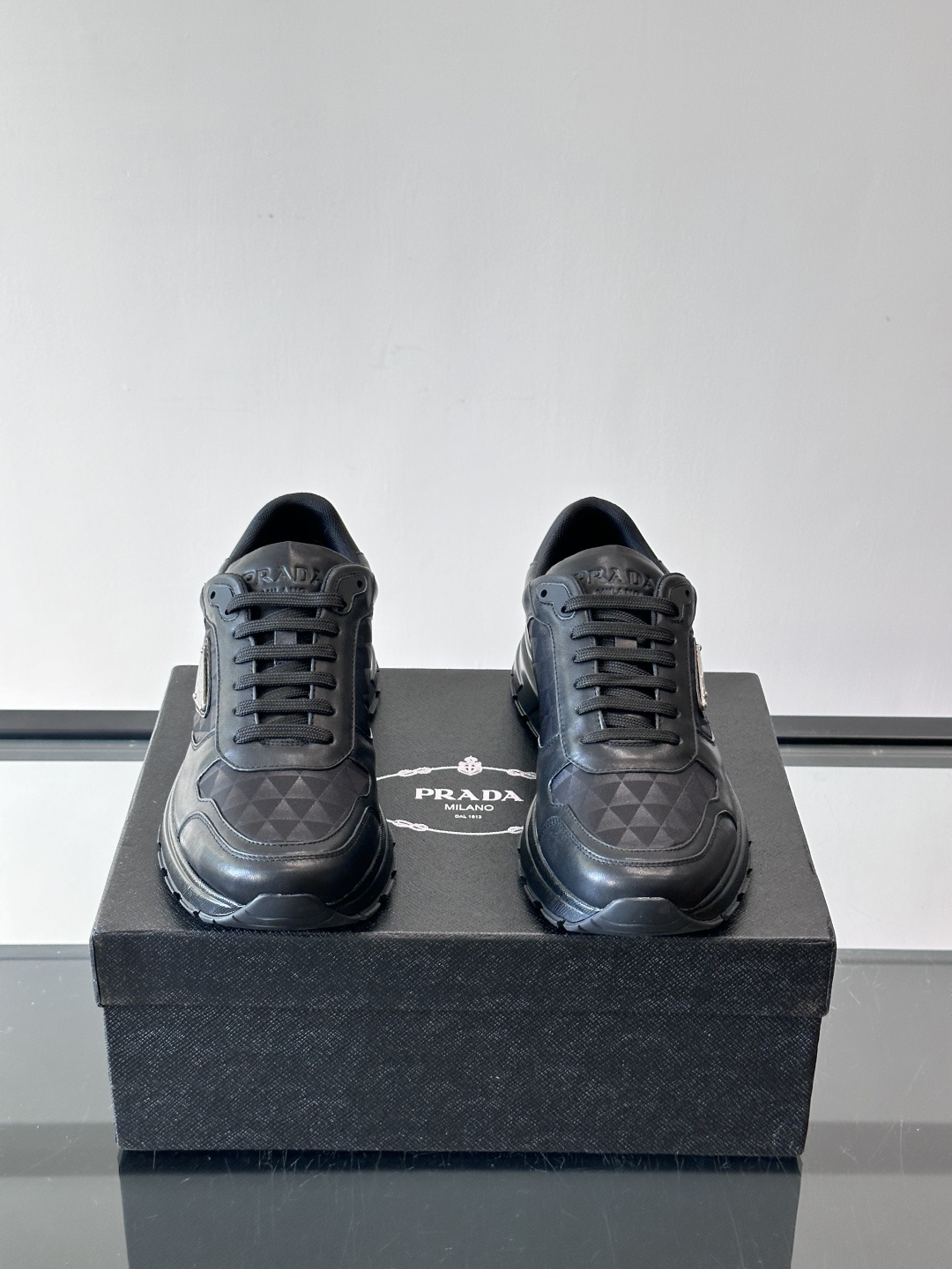 Prada 男士休闲运动鞋。采用麂皮与尼龙面料拼接，质感柔软又耐用，低调奢华。鞋侧三角徽标超有辨识度，橡