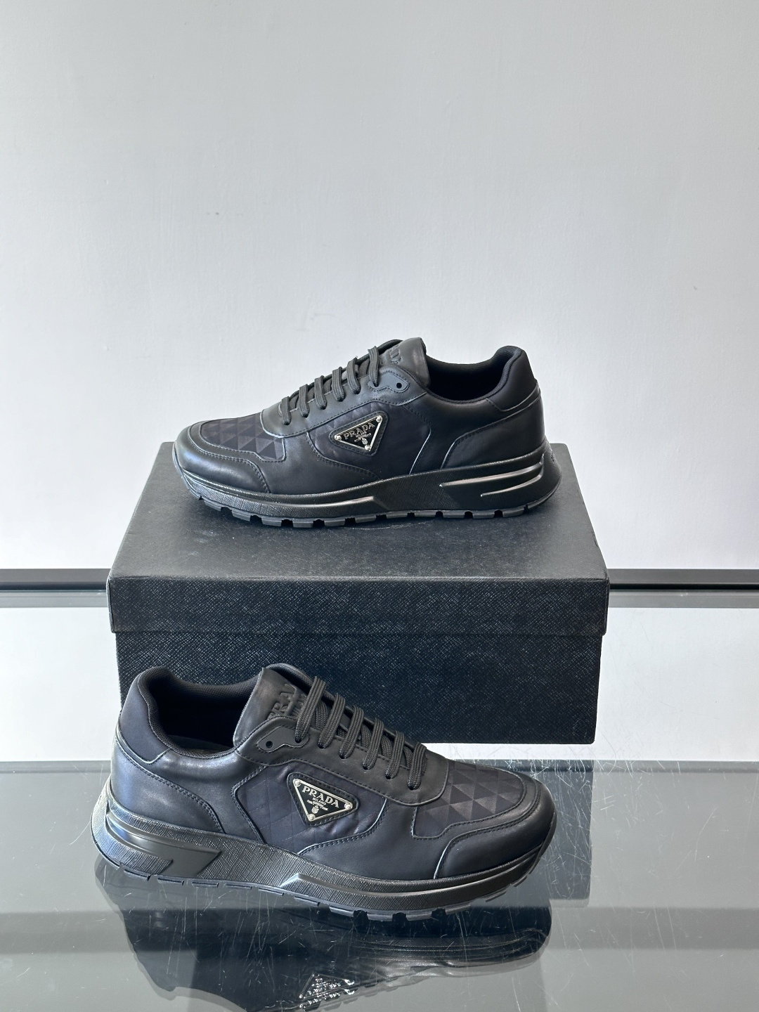 Prada 男士休闲运动鞋。采用麂皮与尼龙面料拼接，质感柔软又耐用，低调奢华。鞋侧三角徽标超有辨识度，橡