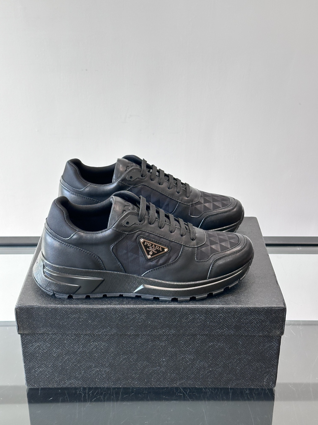Prada 男士休闲运动鞋。采用麂皮与尼龙面料拼接，质感柔软又耐用，低调奢华。鞋侧三角徽标超有辨识度，橡