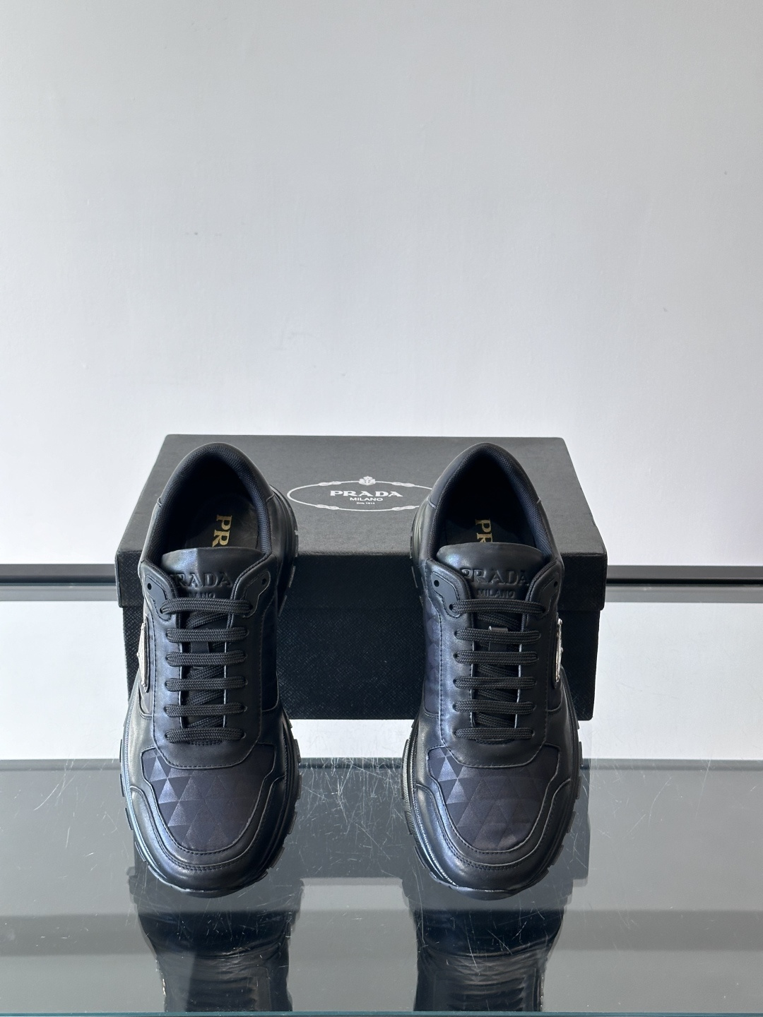 Prada 男士休闲运动鞋。采用麂皮与尼龙面料拼接，质感柔软又耐用，低调奢华。鞋侧三角徽标超有辨识度，橡