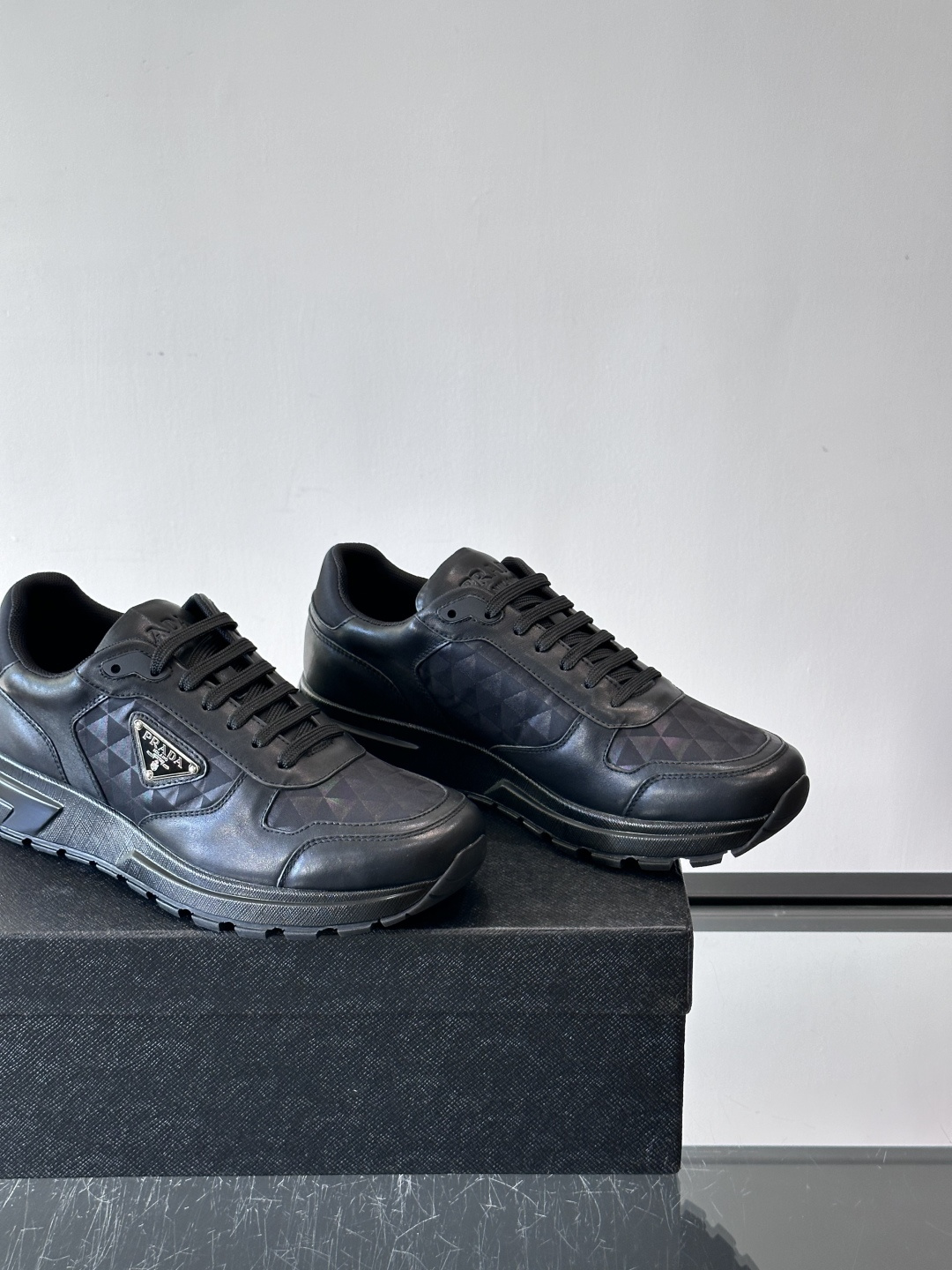 Prada 男士休闲运动鞋。采用麂皮与尼龙面料拼接，质感柔软又耐用，低调奢华。鞋侧三角徽标超有辨识度，橡