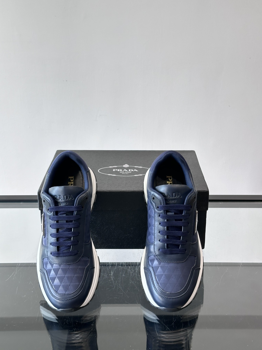 Prada 男士休闲运动鞋。采用麂皮与尼龙面料拼接，质感柔软又耐用，低调奢华。鞋侧三角徽标超有辨识度，橡