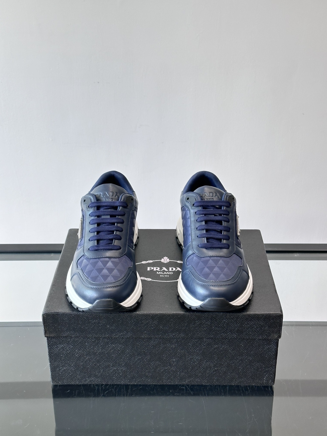Prada 男士休闲运动鞋。采用麂皮与尼龙面料拼接，质感柔软又耐用，低调奢华。鞋侧三角徽标超有辨识度，橡