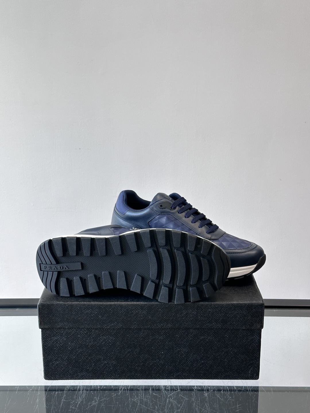 Prada 男士休闲运动鞋。采用麂皮与尼龙面料拼接，质感柔软又耐用，低调奢华。鞋侧三角徽标超有辨识度，橡