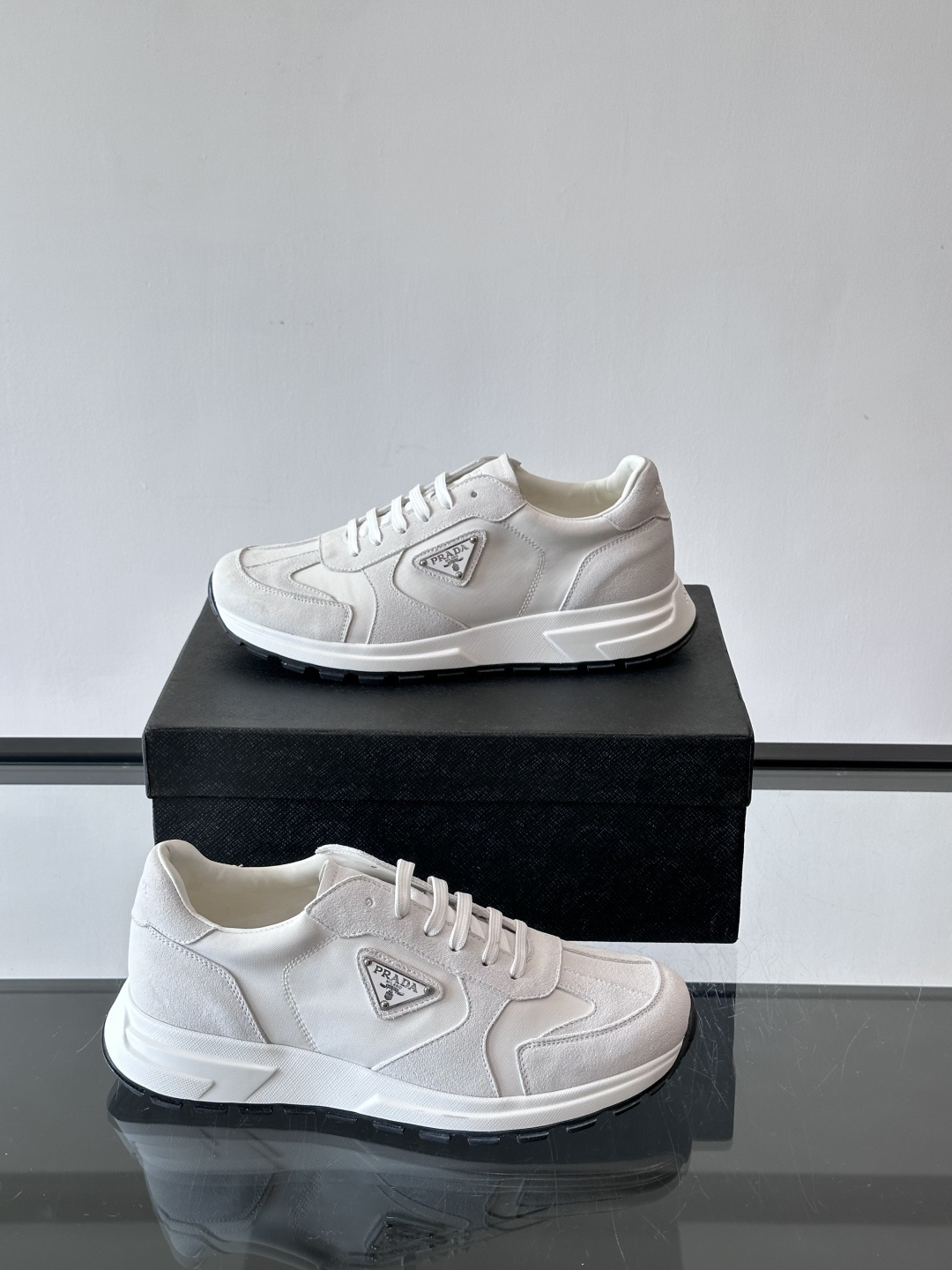Prada 男士休闲运动鞋。采用麂皮与尼龙面料拼接，质感柔软又耐用，低调奢华。鞋侧三角徽标超有辨识度，橡